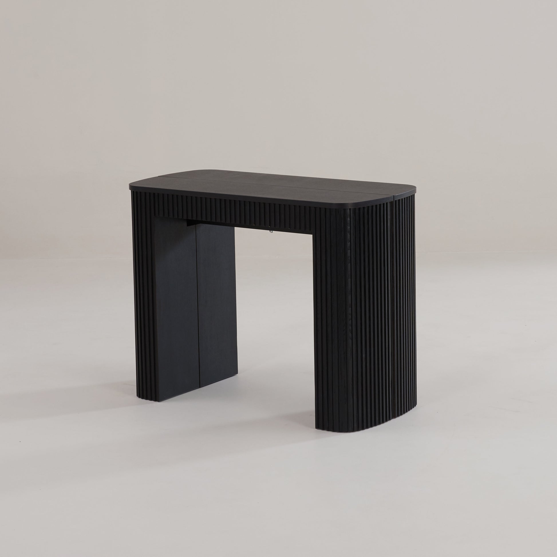Junior Giant Curve in black oak wood as a compact extendable table