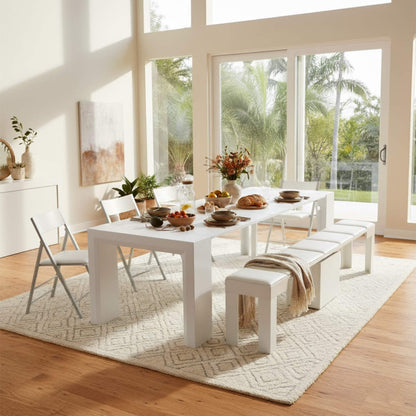 White gloss junior giant table extended for dining with paired extending bench and nano folding chairs in a modern warm home