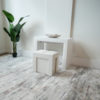 Mini Scatola in white being used as a seat in front of the junior giant white glossy console